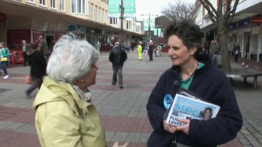 Flick talking to a voter at a street stall